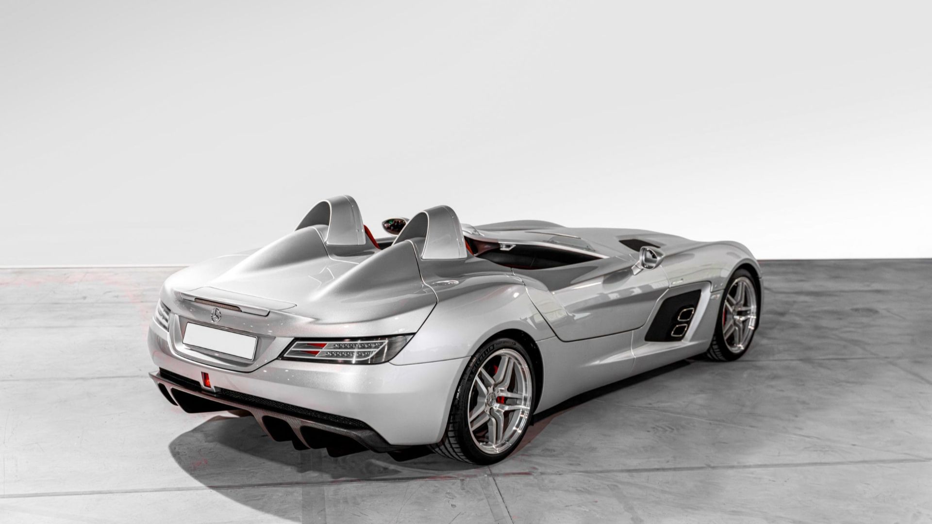 Rear three-quarter view of a silver Mercedes-Benz SLR McLaren Stirling Moss showing its twin headrest fairings