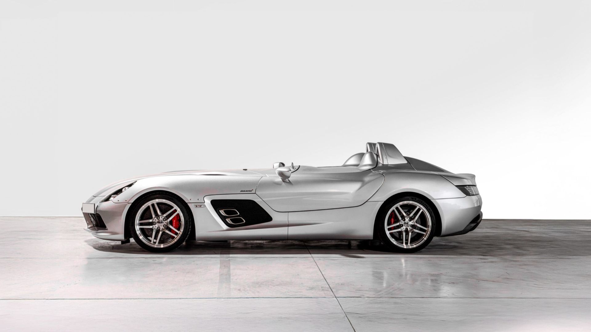Silver Mercedes-Benz SLR McLaren Stirling Moss speedster in side profile with no roof or windshield
