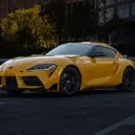 Toyota GR Supra Sales Surge as Production Nears End a yellow sports car parked in a parking lot