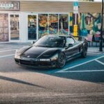 A black sports car parked in front of a store