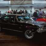 a group of people standing around a car show