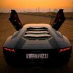 Lamborghini CEO Defends EV Cancellation as Ferrari Faces Criticism Over Electric Debut closeup photo of gray coupe on desert