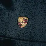 a close up of a car's emblem on a wet surface