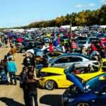 people standing beside blue and yellow cars during daytime