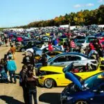 people standing beside blue and yellow cars during daytime