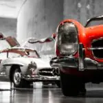 two vintage cars beside gray concrete wall