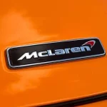 Adele Toured McLaren's Woking HQ, and the Real Story Is the Building She Walked Through blue and white ford logo