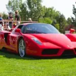 red ferrari 458 italia on green grass field during daytime