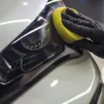 a person with a sponge on a car