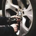The Best Tire Inflators, Pressure Gauges, and Flat-Spot Savers for Stored Cars person in black jacket holding black smartphone