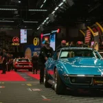 Weekend Wrap-Up: Collector Car Auctions of July 24–26, 2026 A teal classic car drives across an auction stage.