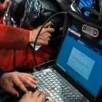 A man sitting in a car using a laptop computer