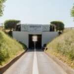 a road going into a tunnel with a sign on it