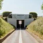 Goodwood Road Racing Club Comes to America: What Enthusiasts Should Know a road going into a tunnel with a sign on it