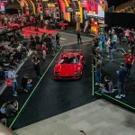Mecum Returns to Monterey Car Week for 17th Year With 600 Collector Cars and 50 Motorcycles Red sports car drives through auction crowd