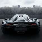 a black sports car driving down a street
