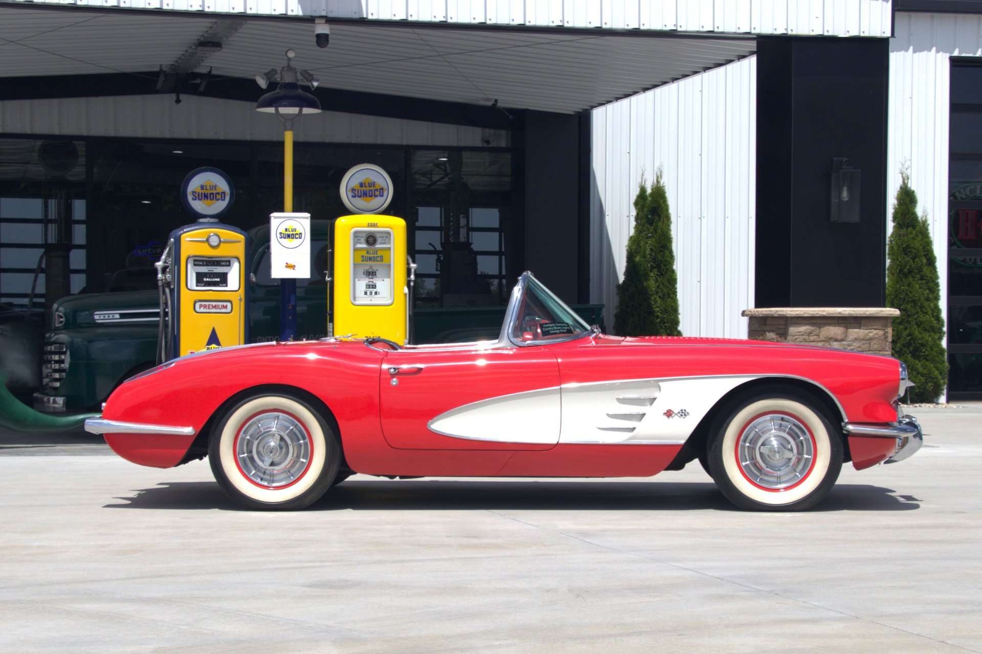 1958 Chevrolet Corvette formerly owned by George Strait, side profile by vintage gas pumps, for sale at GAA Classic Cars