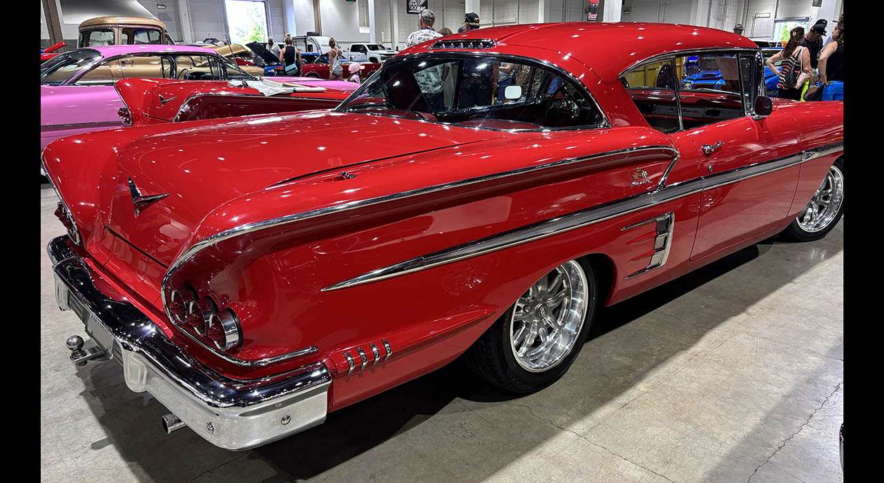 Passenger-side rear view of the restored 1958 Chevrolet Impala hardtop with bright chrome bumpers