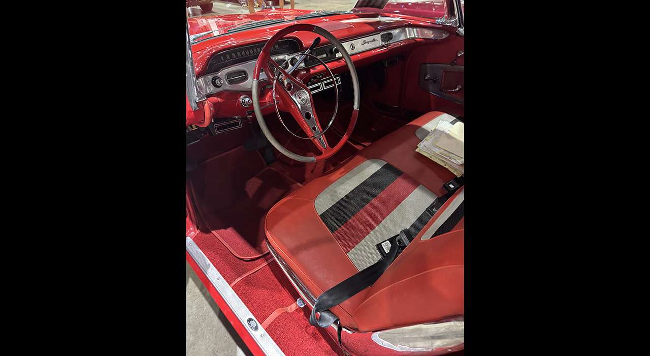 Restored red vinyl interior and steering wheel of the 1958 Chevrolet Impala