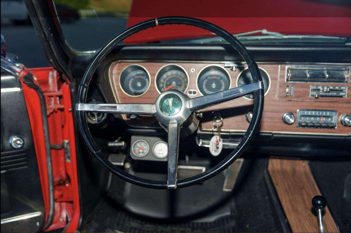 Woodgrain dashboard and gauges inside the 1967 Pontiac GTO at Henderson Auctions
