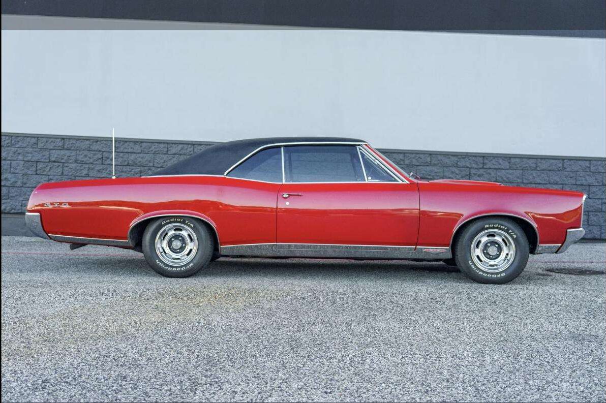 Red 1967 Pontiac GTO side profile with black vinyl top at Henderson Auctions