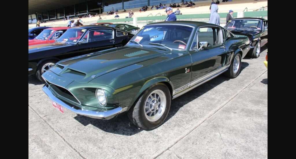 Highland Green 1968 Shelby GT500KR fastback parked among other Shelby Mustangs at a car show