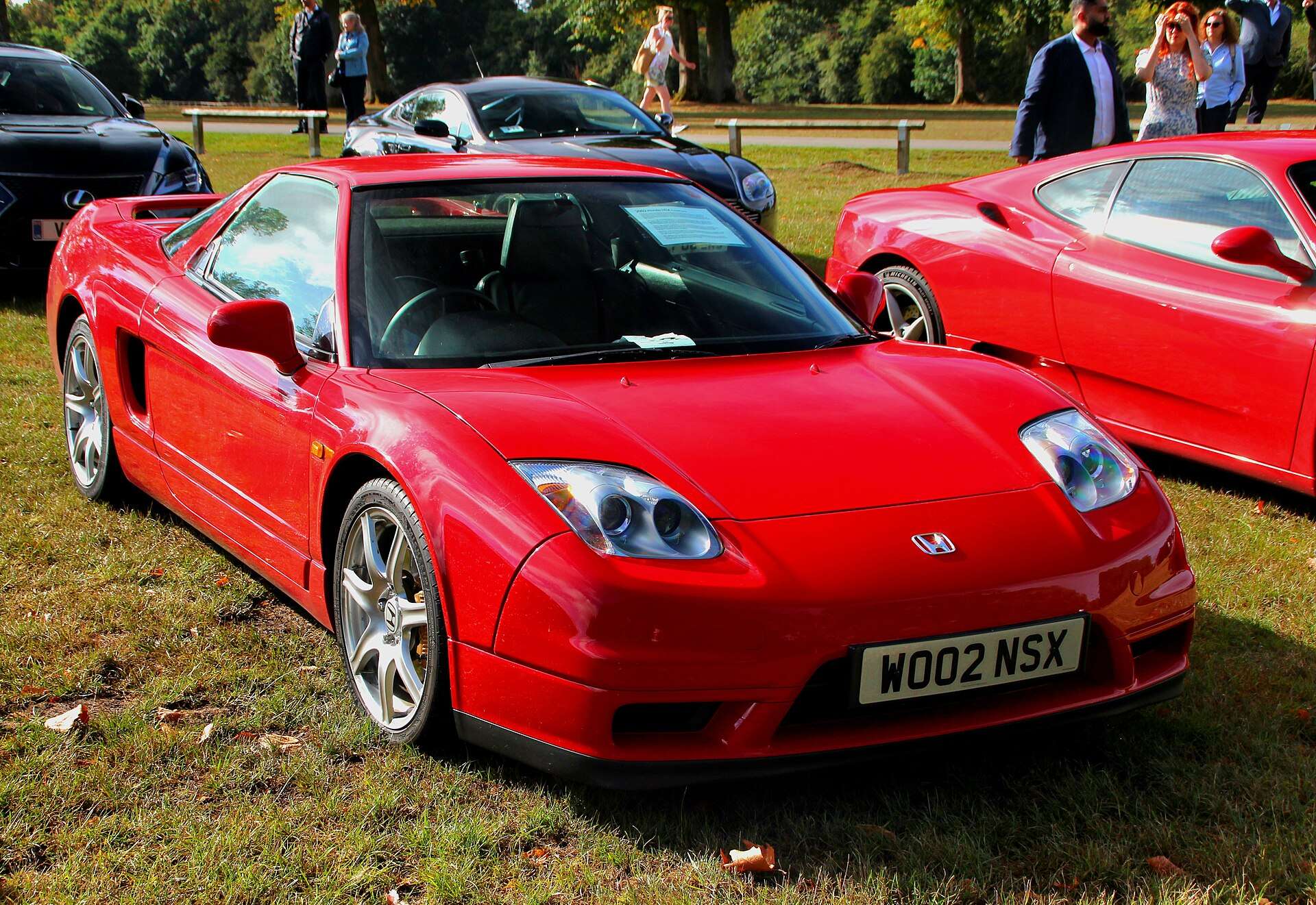 Red 2002 Honda NSX showing the facelift fixed xenon HID headlights that replaced the pop-up lamps