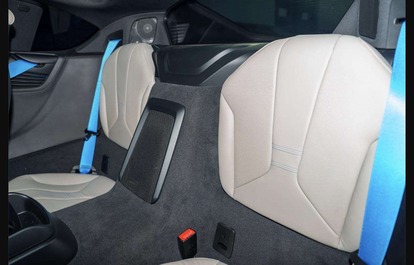 Rear seats and blue seat belts inside the 2015 BMW i8 at Henderson Auctions