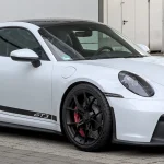 Double Your Entries to Win a 2026 Porsche 911 Carrera Cabriolet + $10,000 Cash — Ends 9/13! White Porsche 911 GT3 (992) coupe with swan-neck rear wing, front three-quarter view