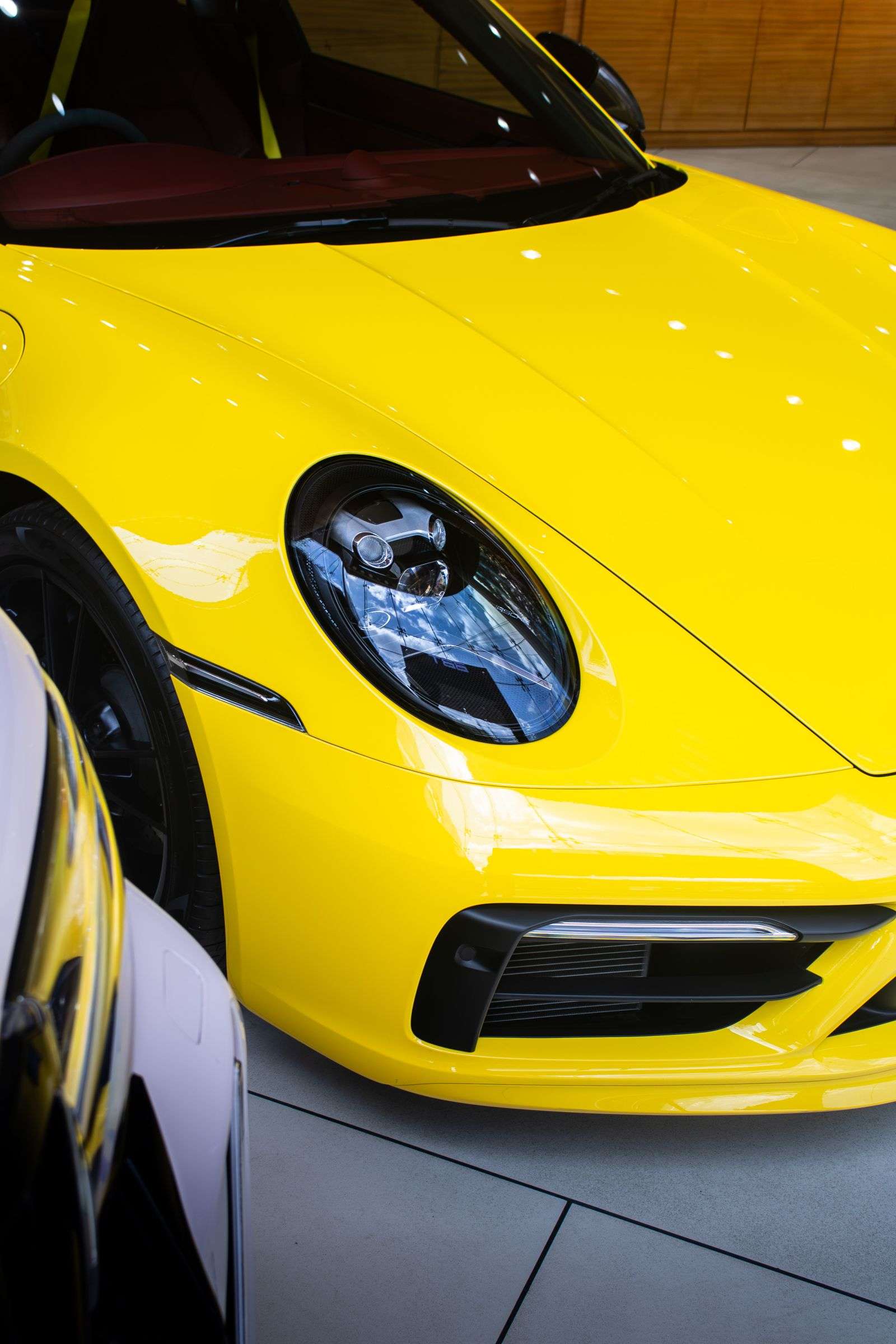 Front fender and headlight detail of a yellow Porsche 911