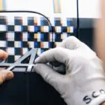 Technicians apply Trevor Jackson's checkered design surface and A390 badge to Alpine's one-off Goodwood Revival art car