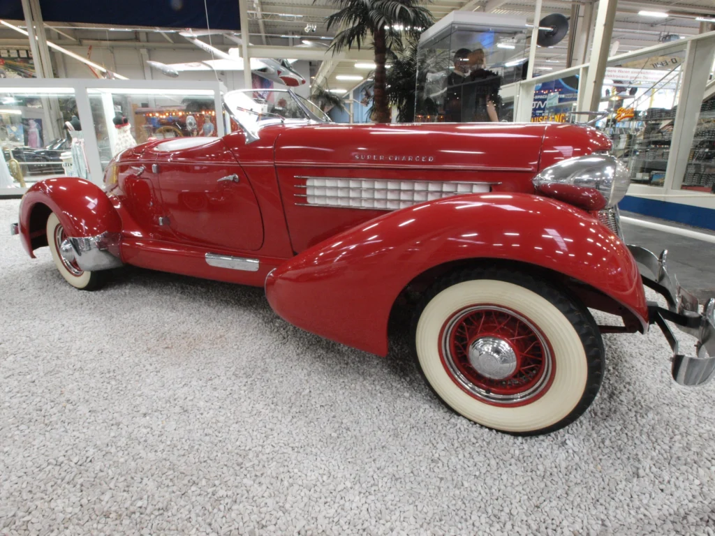 Red Auburn 851 Boattail Speedster in profile showing the chrome side exhaust pipes and tapered tail