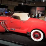 Red 1935 Auburn 851 Supercharged Boattail Speedster with side exhaust pipes and cream top, shown at an auction preview