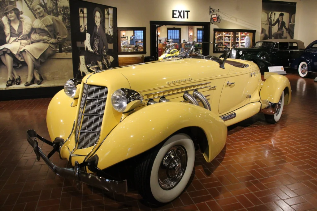 Yellow 1935 Auburn 851 Supercharged Speedster on display in a museum, front three-quarter view