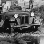 Bantam pilot jeep prototype "Blitz Buggy" carrying three soldiers through mud during Army testing at Camp Holabird, Maryland, in September 1940