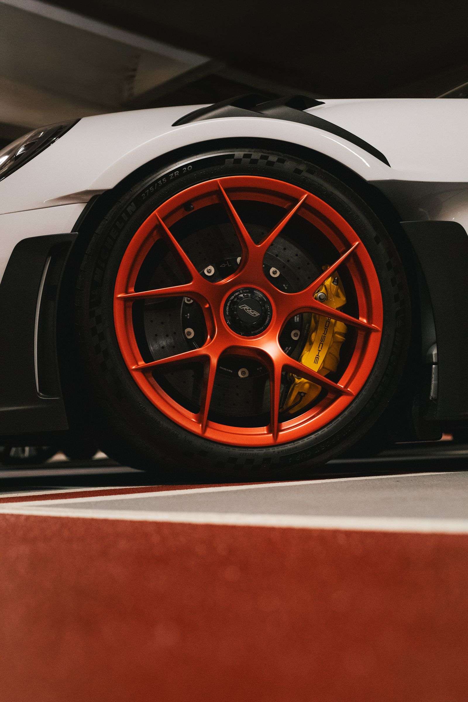Close detail of an orange alloy wheel and brake caliper