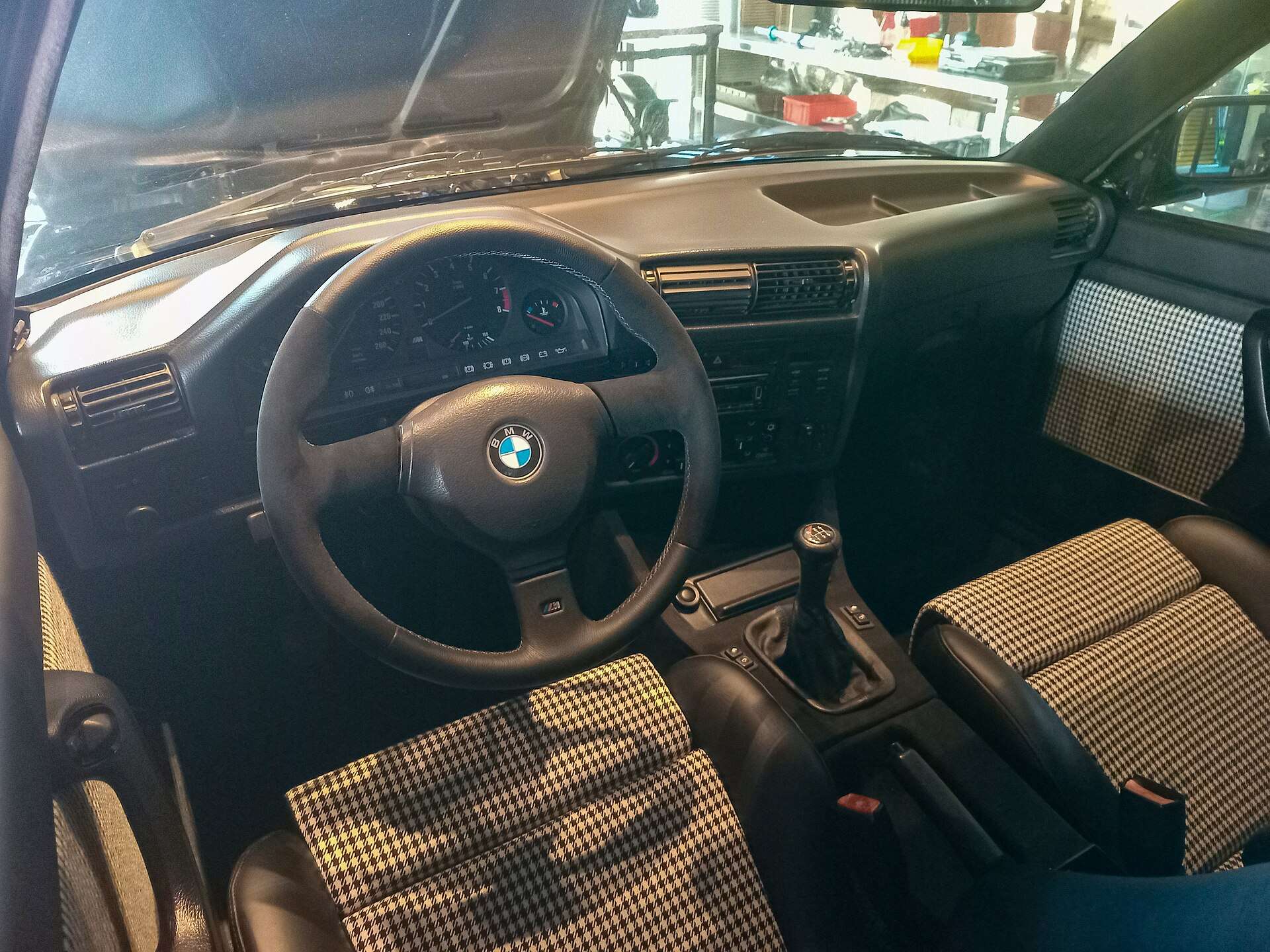 Dashboard and cloth sport seats inside a late-1980s BMW coupe