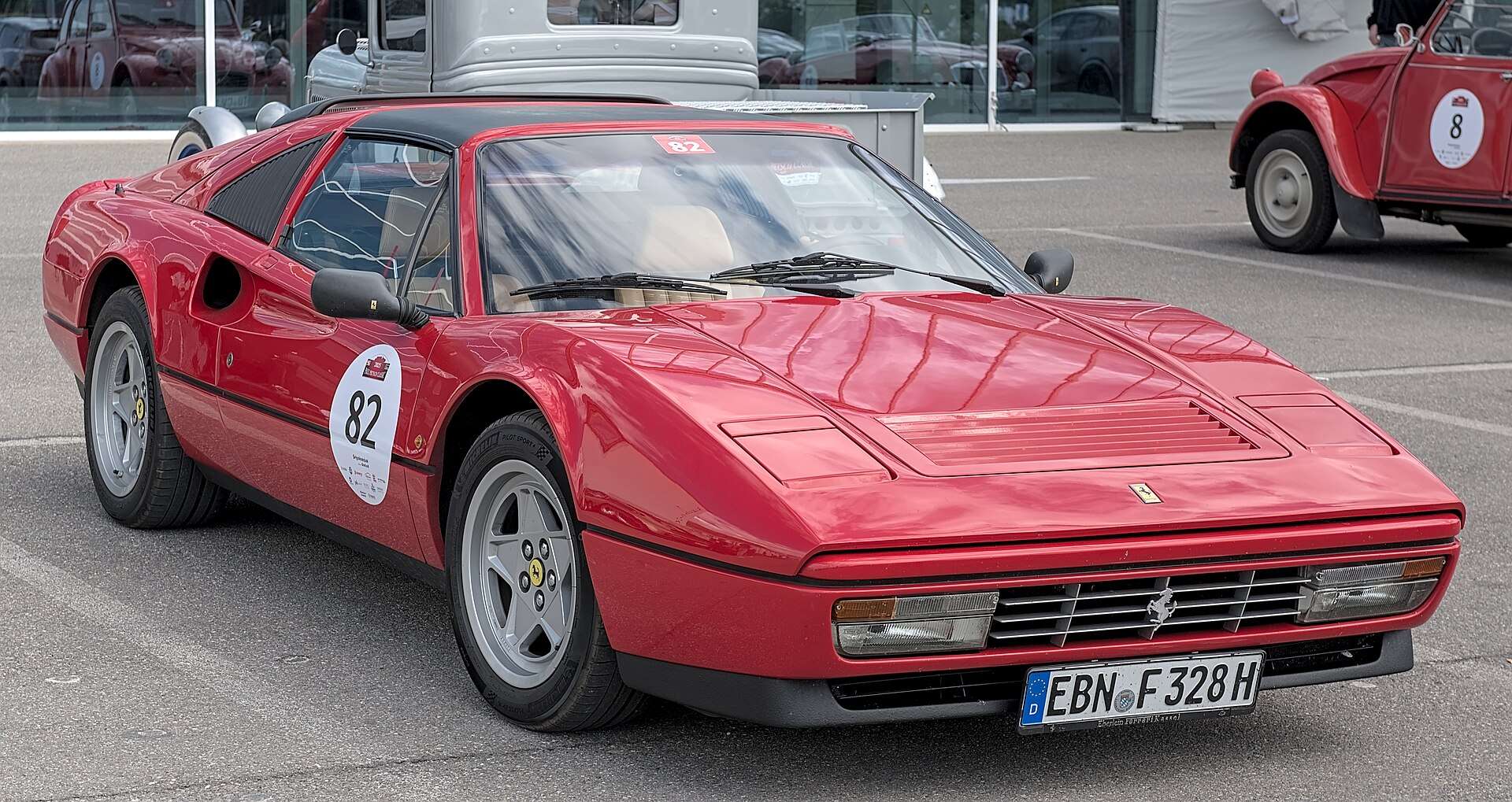 Red Ferrari 328 GTS front three-quarter view at a classic rally