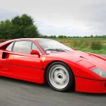 Red Ferrari F40 being driven on a public road