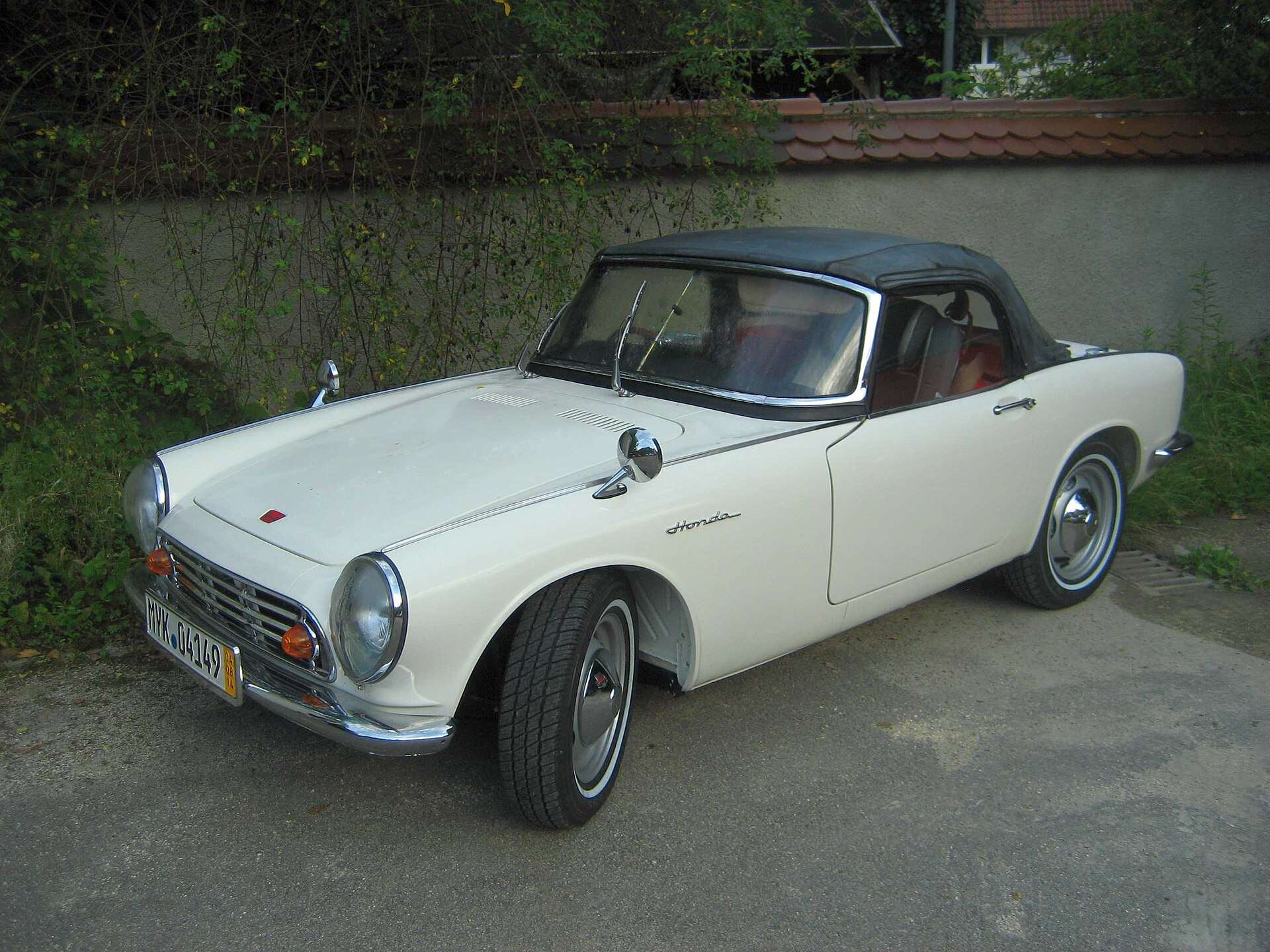 Red Honda S500 roadster with its top up