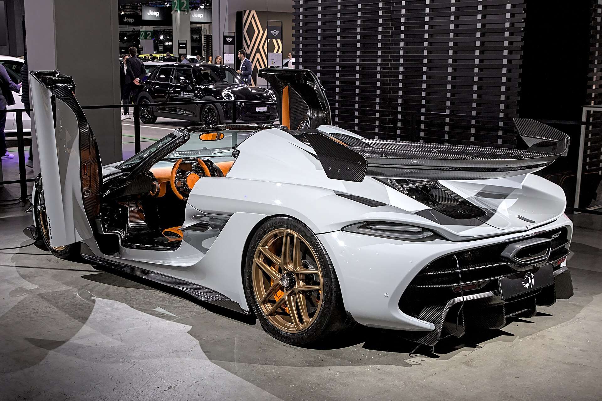 White Koenigsegg Jesko rear three-quarter view showing large carbon rear wing and dihedral door