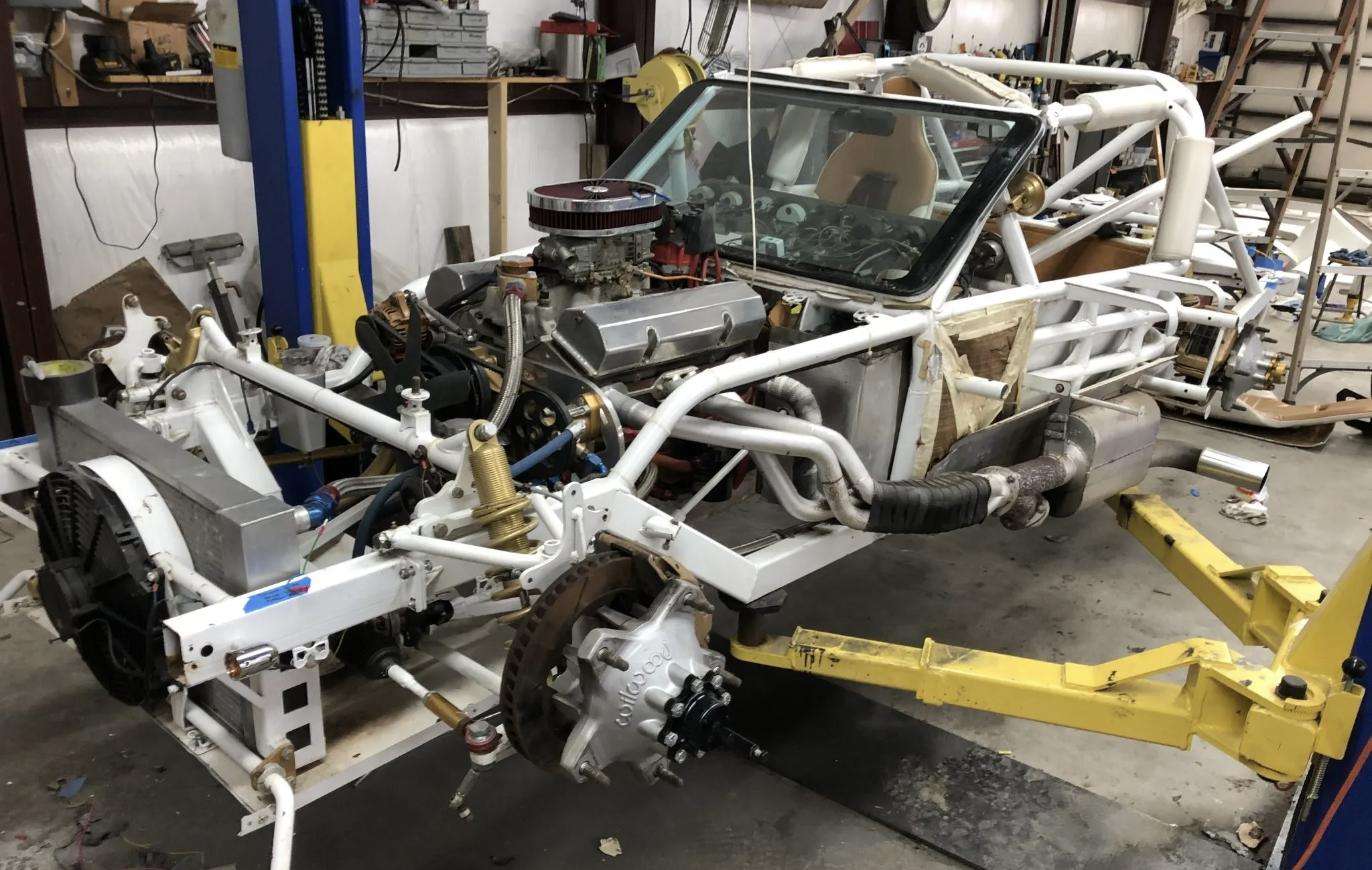 The fabricated tube chassis and 409 Chevrolet V8 on the lift during construction