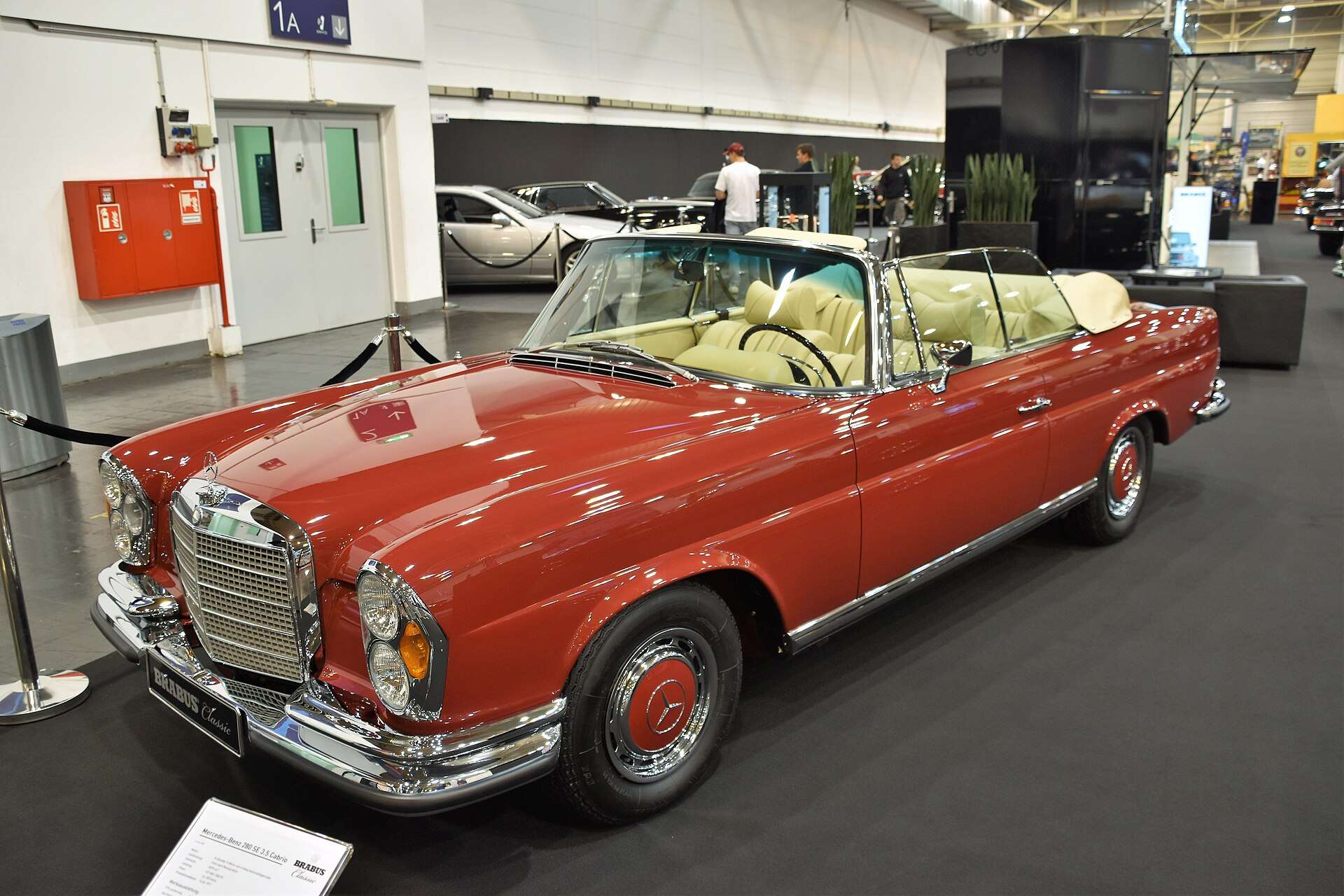 Red Mercedes-Benz 280 SE 3.5 Cabriolet W111 with cream interior on display