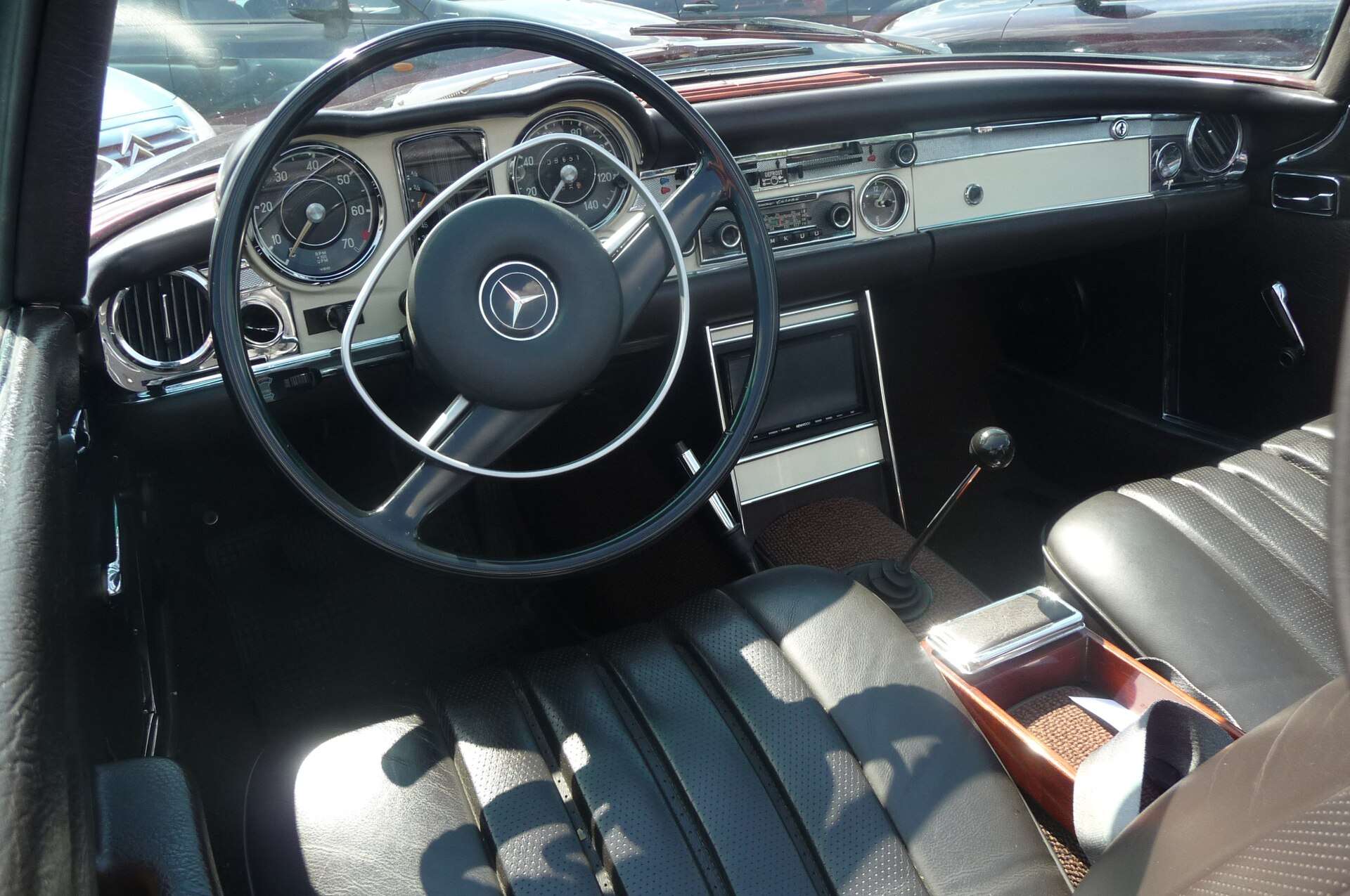 Interior of a 1969 Mercedes-Benz 280 SL with dashboard, steering wheel and seats