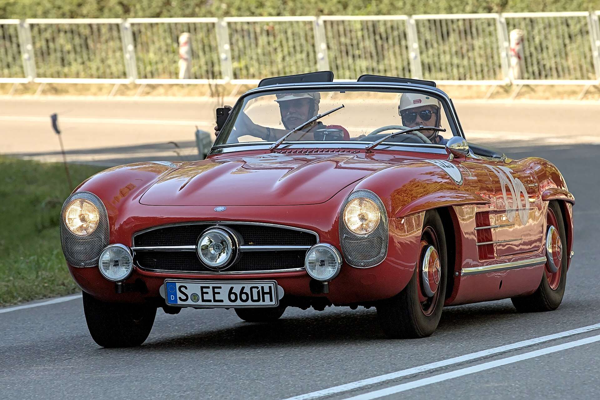 Red Mercedes-Benz 300 SL Roadster W198 driving on a closed road