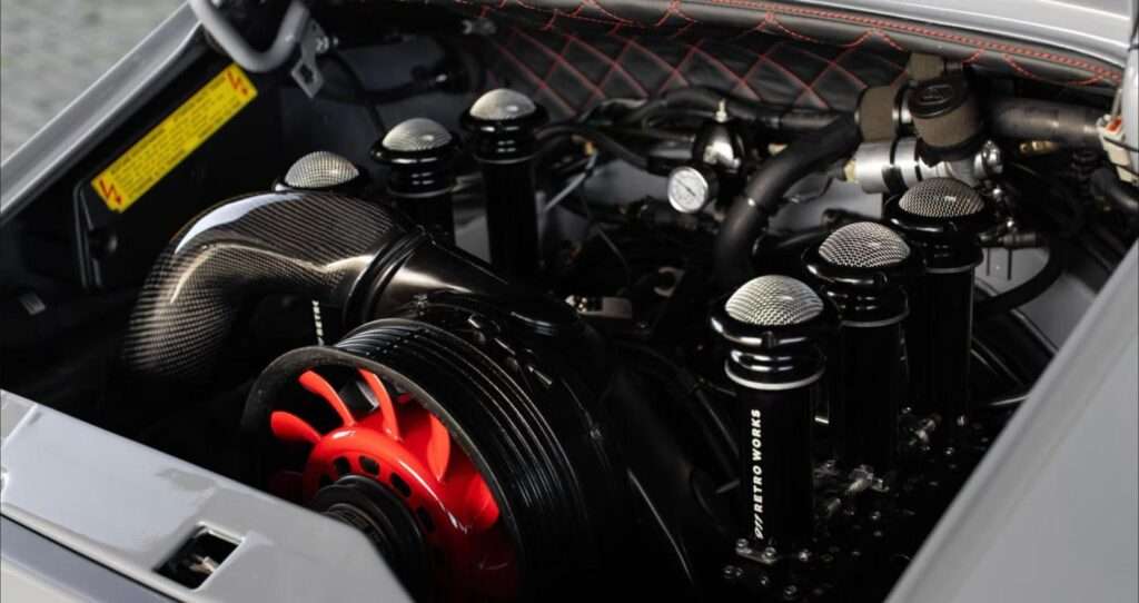 Air-cooled Porsche flat-six engine bay with individual throttle bodies and a rebuilt crankcase