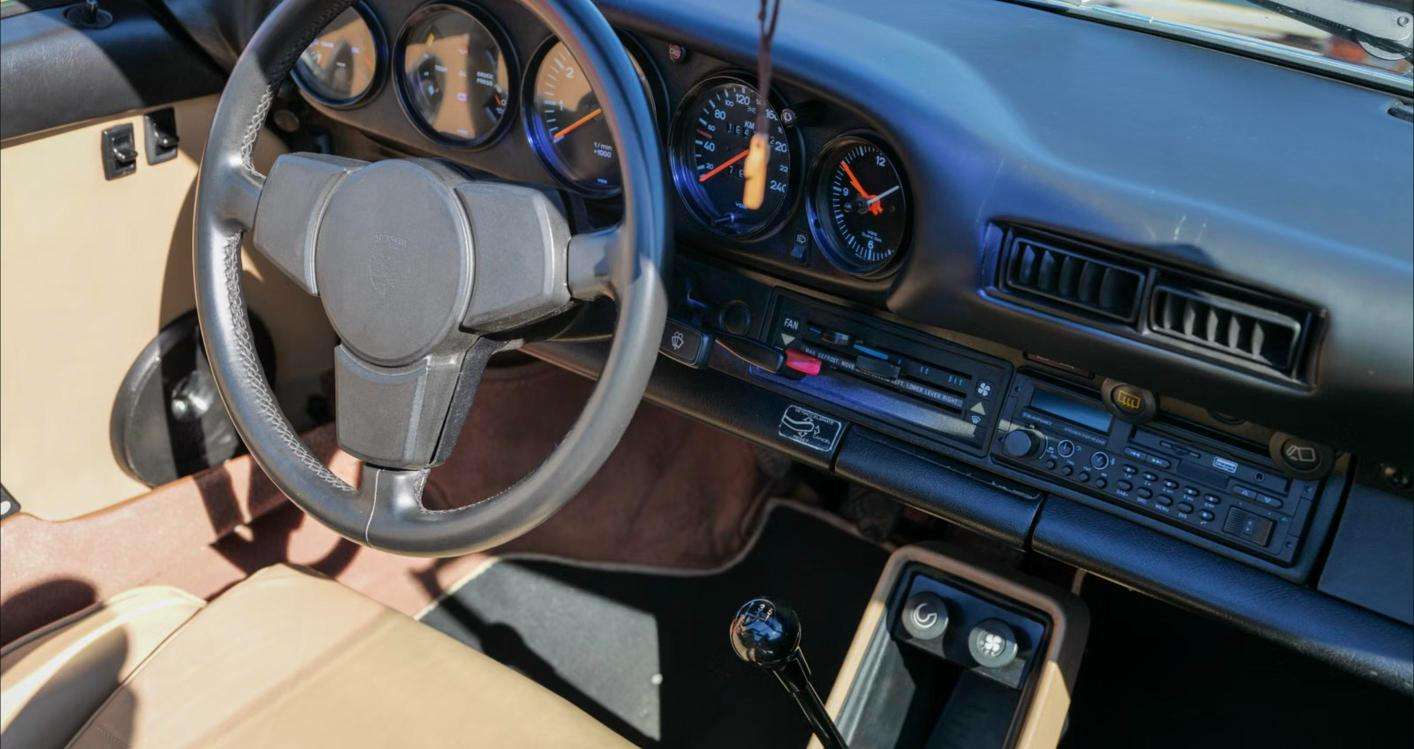 Porsche 911 interior showing the five-gauge dashboard, tachometer and four-spoke steering wheel