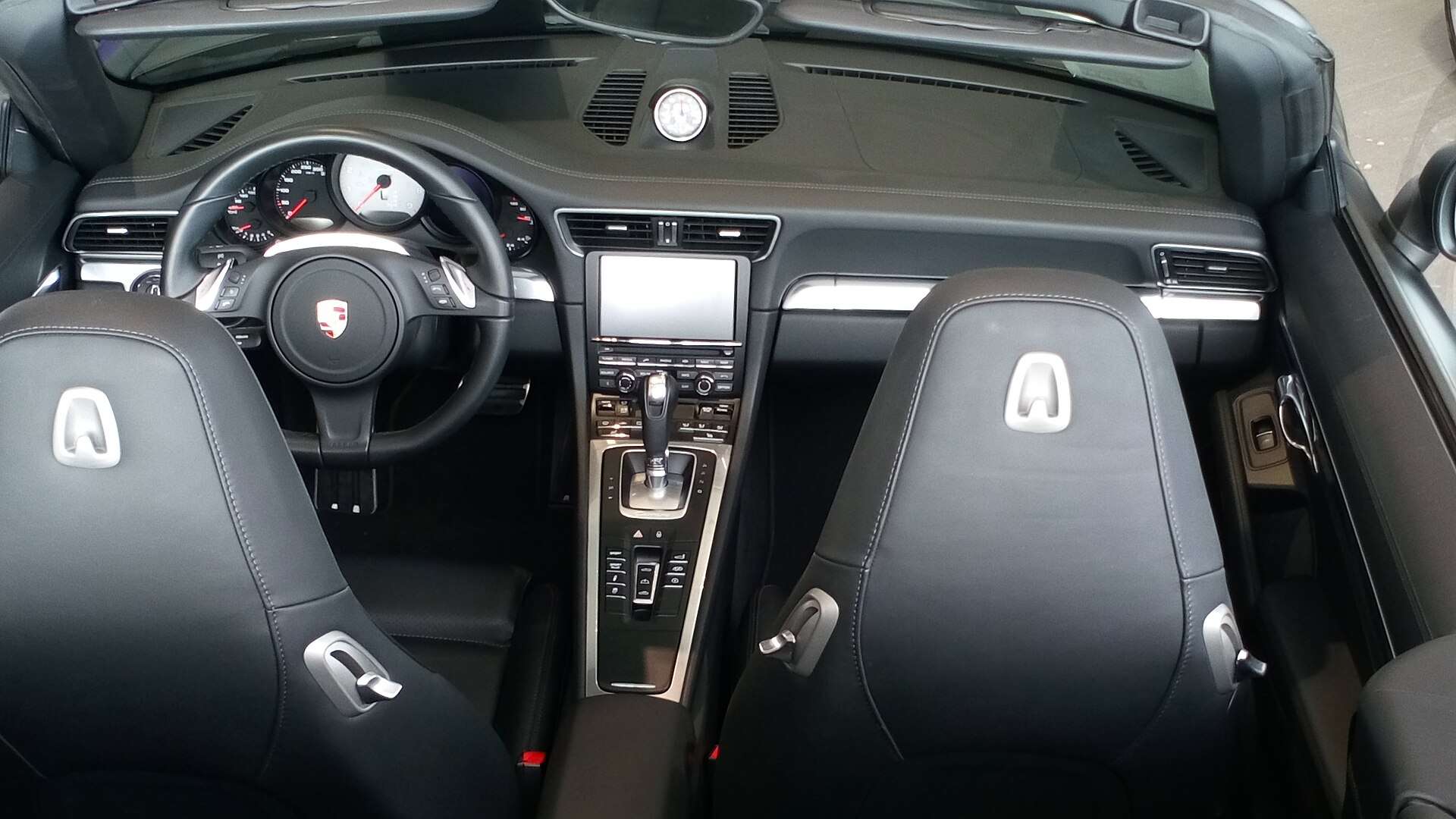 Dashboard and center console of a 991-generation Porsche 911 showing the factory infotainment screen
