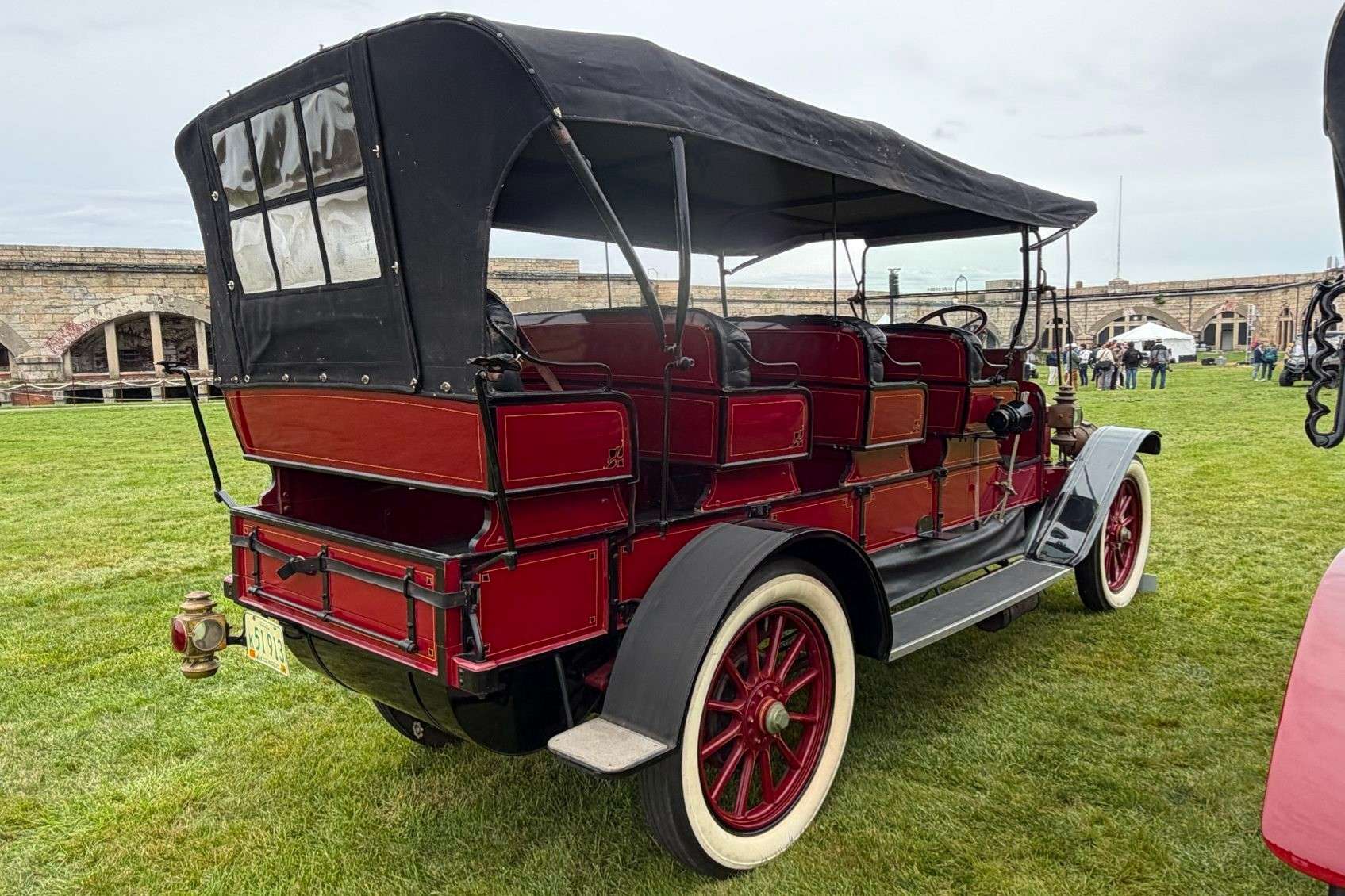 Rear view of the red 1913 Stanley Mountain Wagon showing the tailgate and the six-pane rear window in the black soft top