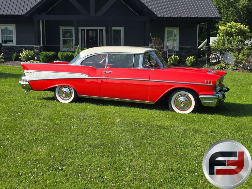 Side profile of the red and white 1957 Chevrolet Bel Air with whitewall tires